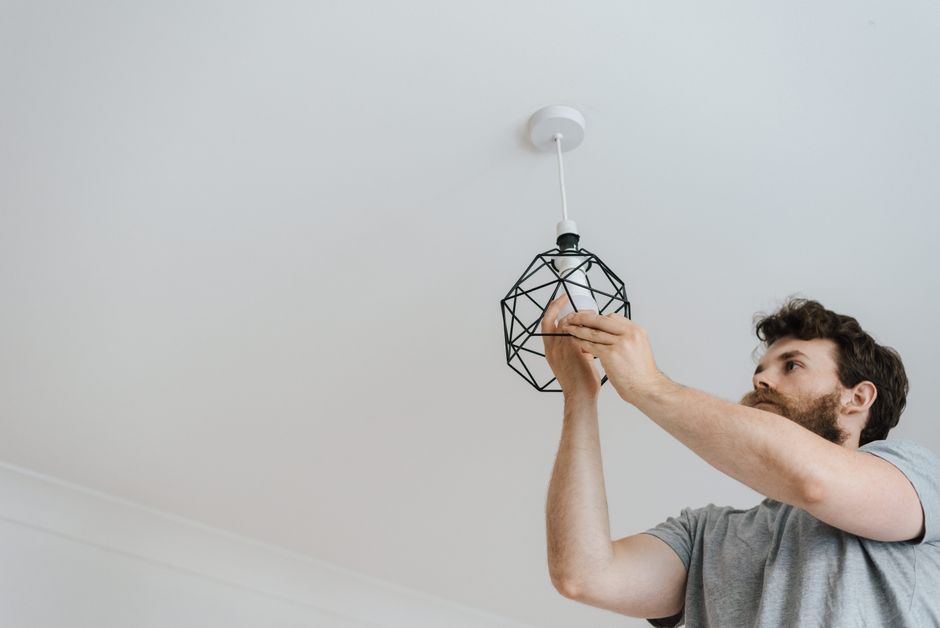 Iemand sluit de draden van een plafondlamp aan